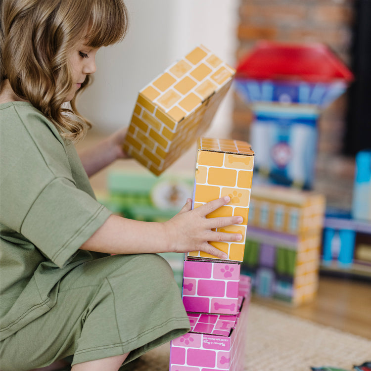 A kid playing with The Melissa & Doug PAW Patrol Jumbo Cardboard Blocks (41 Pieces)