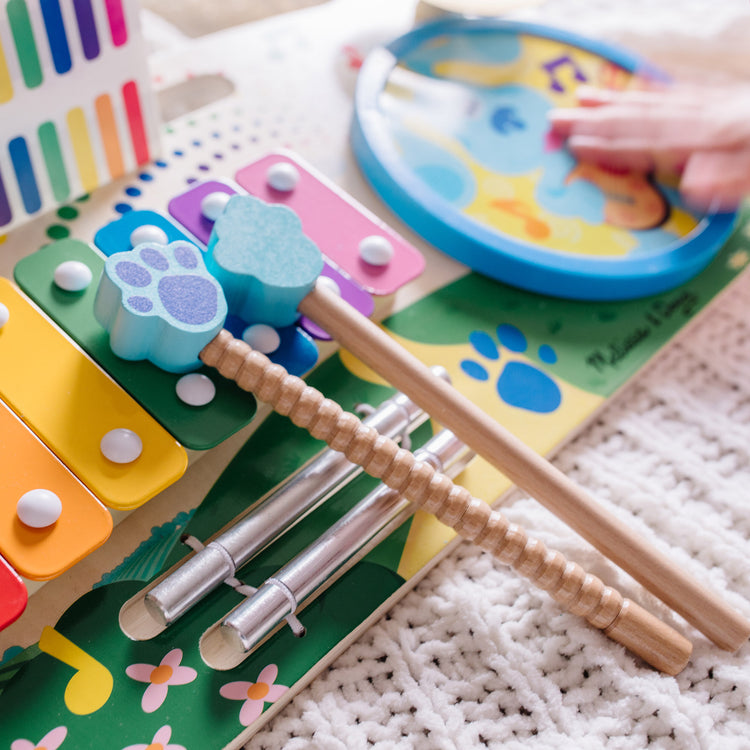 A kid playing with The Melissa & Doug Blue's Clues & You! Wooden Music Maker Board (5 Instruments)