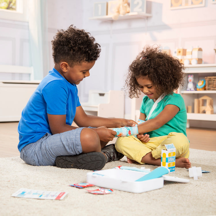 A kid playing with The Melissa & Doug Get Well First Aid Kit Play Set – 25 Toy Pieces