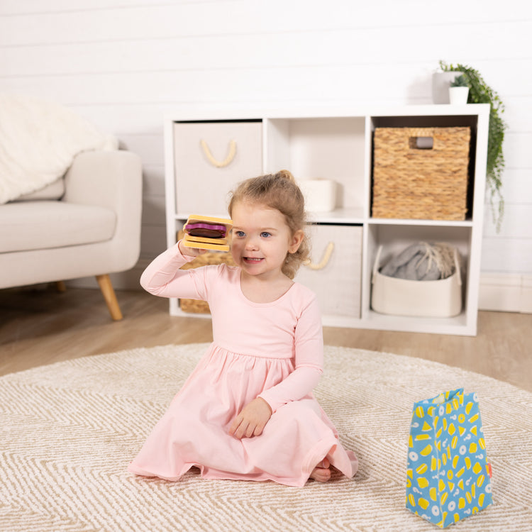 A kid playing with The Melissa & Doug What’s for Lunch?™ Surprise Meal Play Food Set Series 2