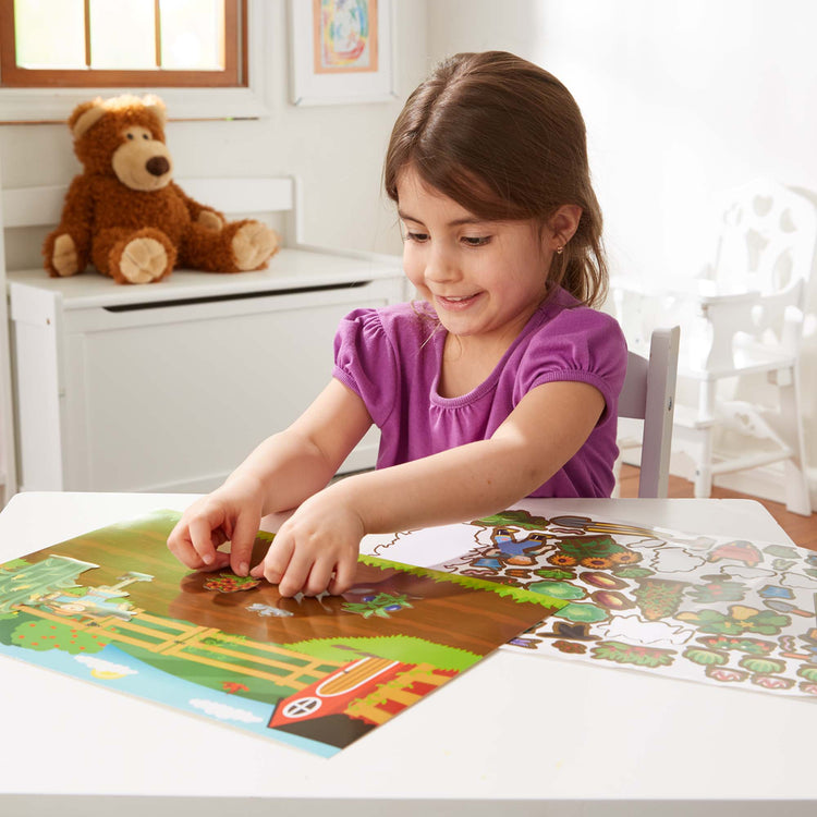 A kid playing with The Melissa & Doug Reusable Sticker Pad Bundle - Jungle, Farm & Under the Sea