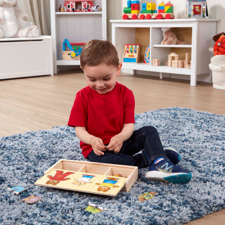 A kid playing with The Melissa & Doug Mix 'n Match Wooden Bear Family Dress-Up Puzzle With Storage Case (45 pcs)