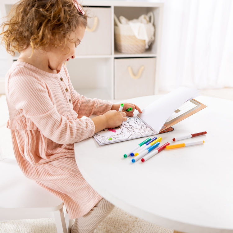 A kid playing with The Magic-Pattern Kids’ Wild Animals Marker Coloring Pad On the Go Travel Activity