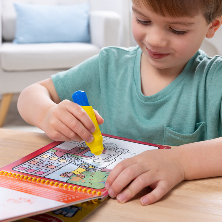 A kid playing with The Melissa & Doug On the Go Water Wow! Reusable Water-Reveal Activity Pad - Vehicles