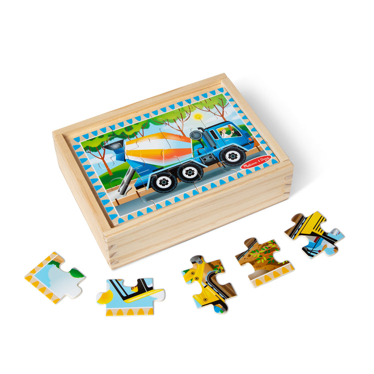 The loose pieces of The Melissa & Doug Construction Vehicles 4-in-1 Wooden Jigsaw Puzzles in a Box (48 pcs)