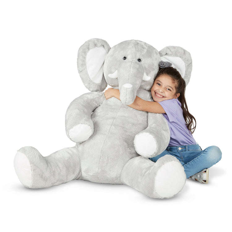A child on white background with The Melissa & Doug Gentle Jumbos Elephant Giant Stuffed Plush Animal (Sits Nearly 3 Feet Tall)