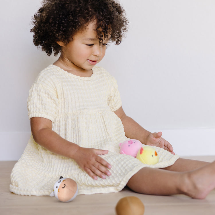 A kid playing with The Melissa & Doug Rollables Farm Friends Infant and Toddler Toy (4 Pieces)