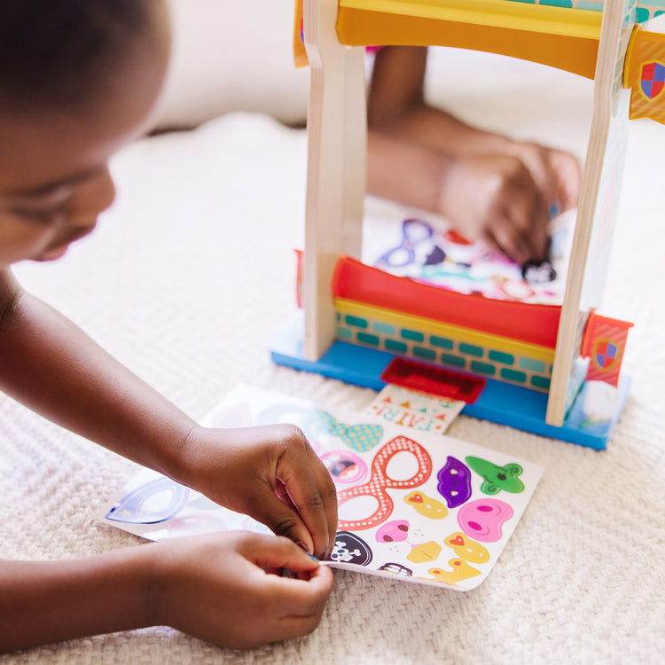 A kid playing with The Melissa & Doug Fun at the Fair! Wooden Double-Sided Funhouse Mirror