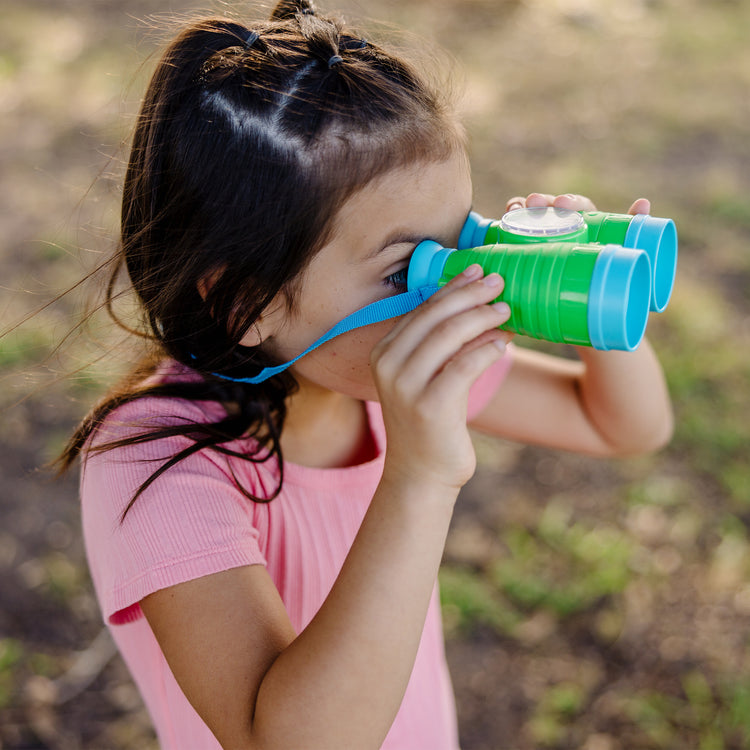 A kid playing with The Melissa & Doug Let's Explore Binoculars & Compass Play Set
