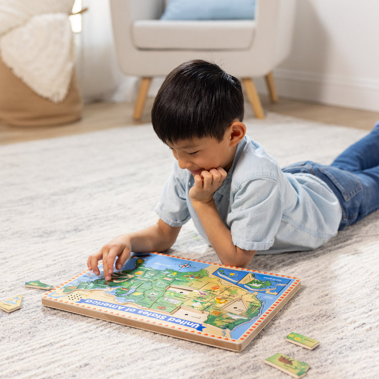 A kid playing with The Melissa & Doug USA Map Sound Puzzle - Wooden Puzzle With Sound Effects (40 pcs), Multicolor