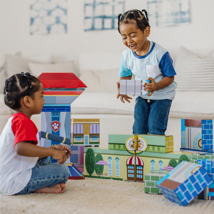 A kid playing with The Melissa & Doug PAW Patrol Jumbo Cardboard Blocks (41 Pieces)