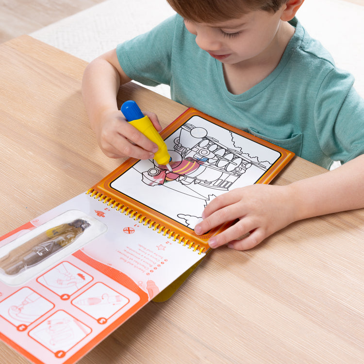 A kid playing with The Melissa & Doug On the Go Water Wow! Reusable Water-Reveal Activity Pad - Vehicles