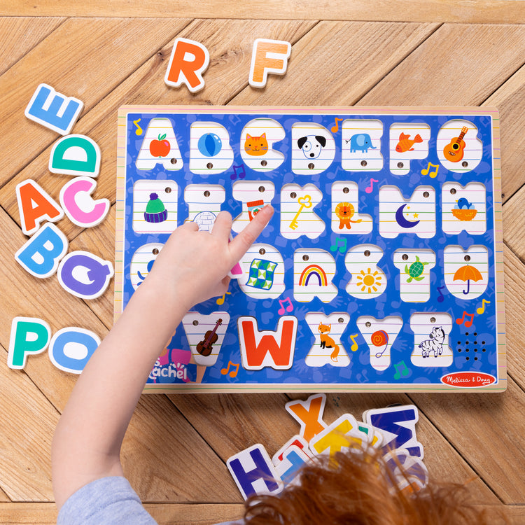 A kid playing with The Melissa & Doug® Ms. Rachel™ Wooden Phonics Alphabet Sound Puzzle, 24-Piece Toddler Toys for Boys and Girls Ages 2+ Years