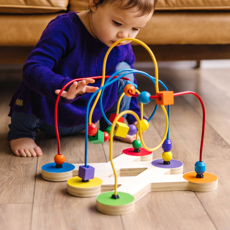 A kid playing with The Melissa & Doug Classic Bead Maze - Wooden Educational Toy