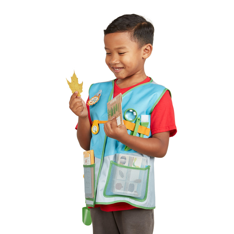 A child on white background with The Melissa & Doug Let’s Explore Naturalist Vest Play Set – 20 Pieces