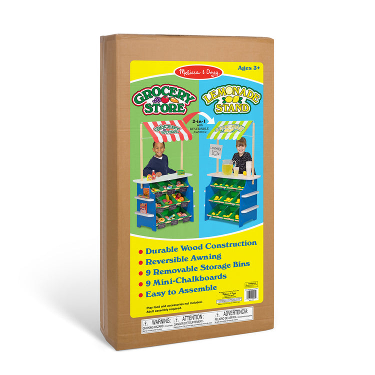 The front of the box for The Melissa & Doug Wooden Grocery Store and Lemonade Stand Activity Center - Reversible Awning, 9 Bins, 9 Chalkboards