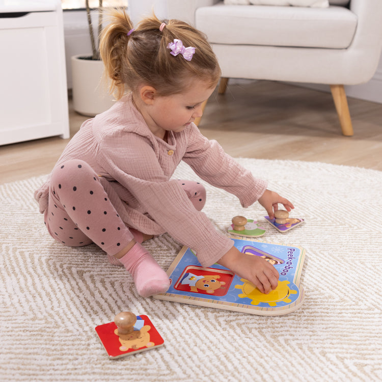 A kid playing with The Melissa & Doug® Ms. Rachel™ Wooden Peek-a-Boo Jumbo Peg Puzzle, 4-Piece with Mirror, Toddler Toys for Boys and Girls Ages 1+ Years

