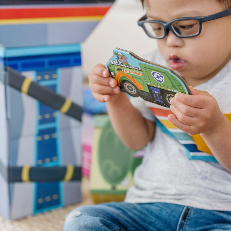 A kid playing with The Melissa & Doug PAW Patrol Jumbo Cardboard Blocks (41 Pieces)