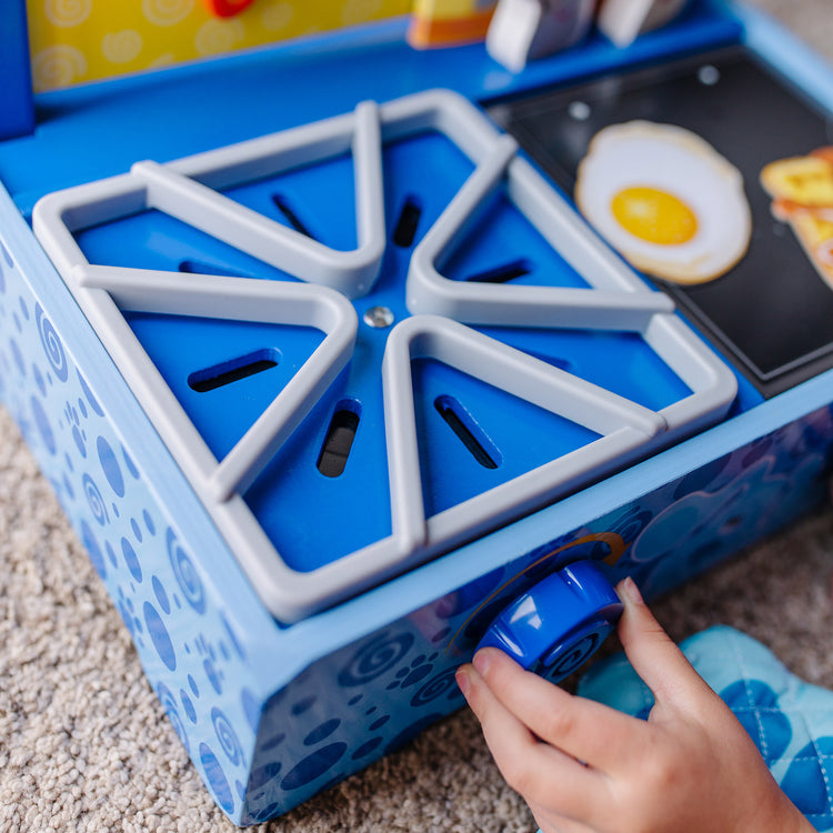 A kid playing with The Melissa & Doug Blue's Clues & You! Wooden Cooking Play Set (42 Pieces)