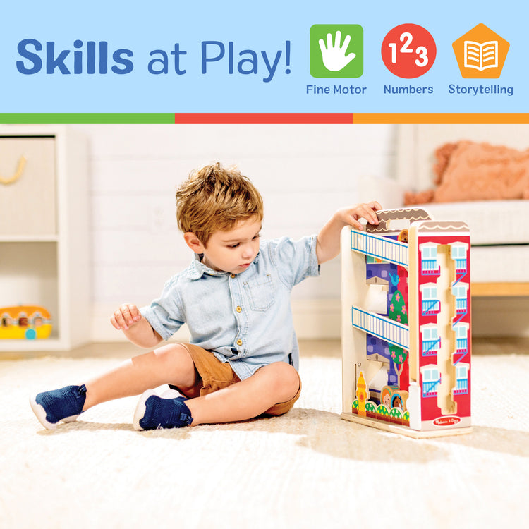 A kid playing with The Melissa & Doug GO Tots Wooden Town House Tumble with 6 Disks