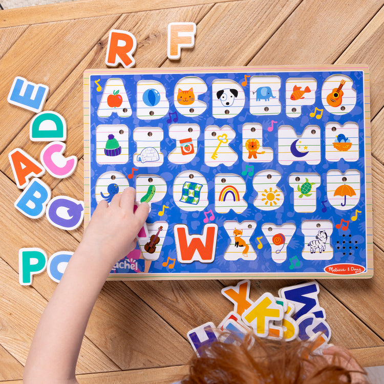 A kid playing with The Melissa & Doug® Ms. Rachel™ Wooden Phonics Alphabet Sound Puzzle, 24-Piece Toddler Toys for Boys and Girls Ages 2+ Years