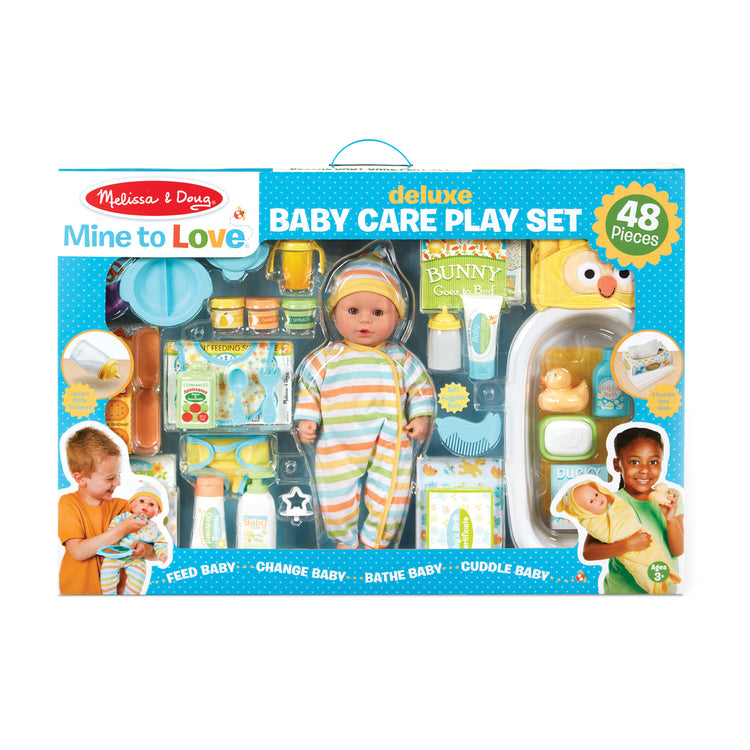 The front of the box for The Melissa & Doug Mine to Love Deluxe Baby Care Play Set (48 Pieces – Doll + Accessories to Feed, Bathe, Change, and Cuddle)