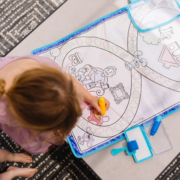 A kid playing with The Melissa & Doug Blue's Clues & You! Water Wow! Activity Mat (20 Inches x 30 Inches) With Reusable Water Reveal Surface