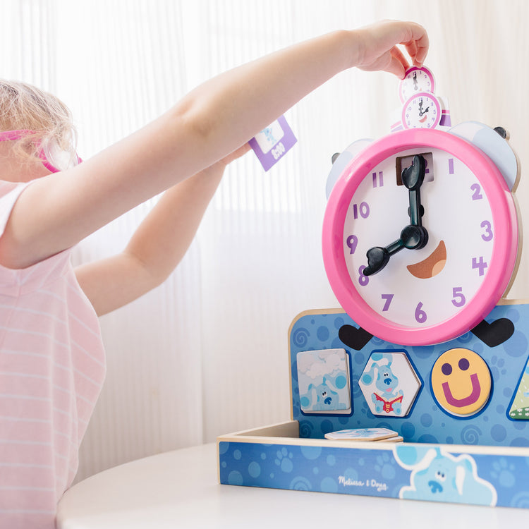 A kid playing with The Melissa & Doug Blue's Clues & You! Wooden Tickety Tock Magnetic Clock (31 Pieces)