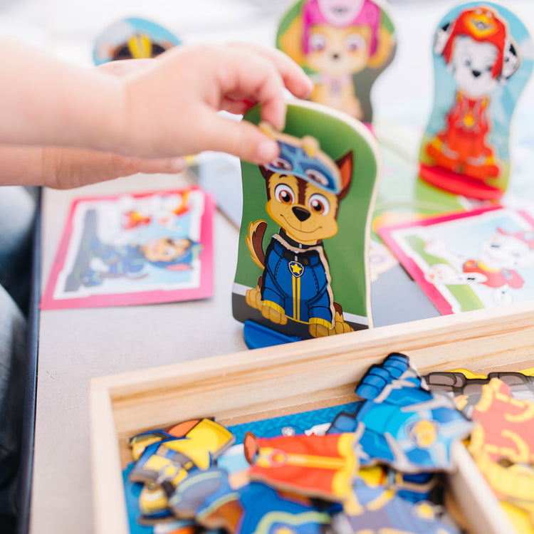 A kid playing with The Melissa & Doug PAW Patrol Wooden Magnetic Pretend Play (64 Pieces), Multi color