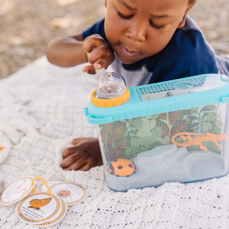 A kid playing with The Melissa & Doug Let’s Explore Terrarium Observations Play Set (16 Pieces)