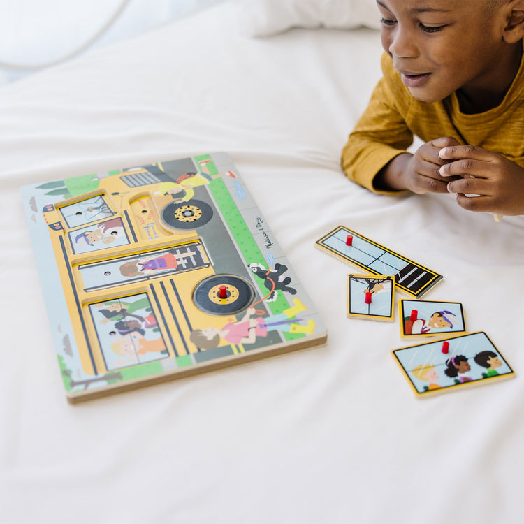 A kid playing with The Melissa & Doug The Wheels on the Bus Sound Puzzle