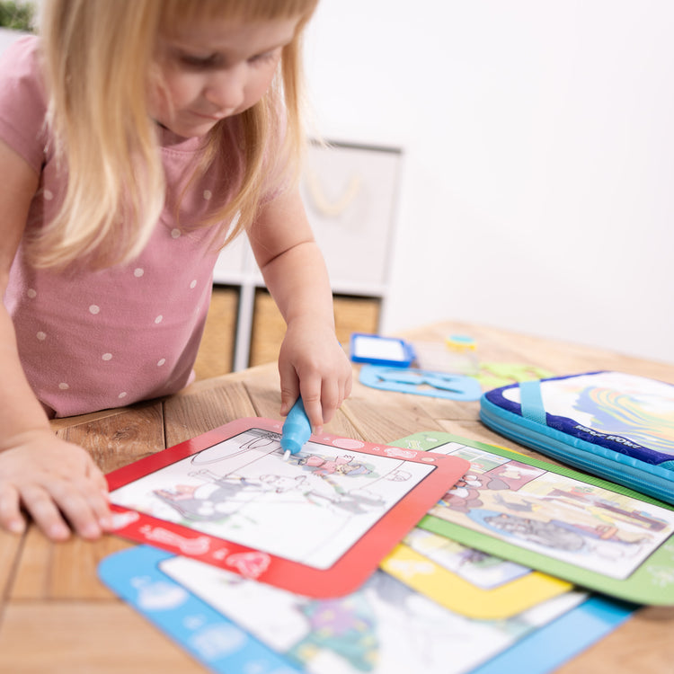 A kid playing with The Melissa & Doug Water WOW! Water WOW! Take-Along Multi-Activity Color-Reveal Drawing Set Travel Toy Ages 3+