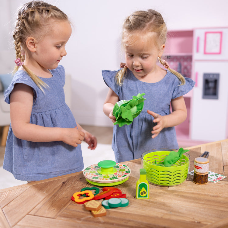 A kid playing with The Melissa & Doug Salad Spinner Play Set, Pretend Play Food for Boys and Girls Ages 3+