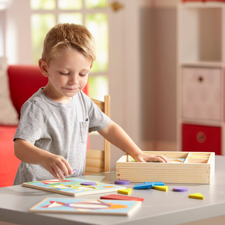 A kid playing with The Melissa & Doug Beginner Wooden Pattern Blocks Educational Toy With 5 Double-Sided Scenes and 30 Shapes