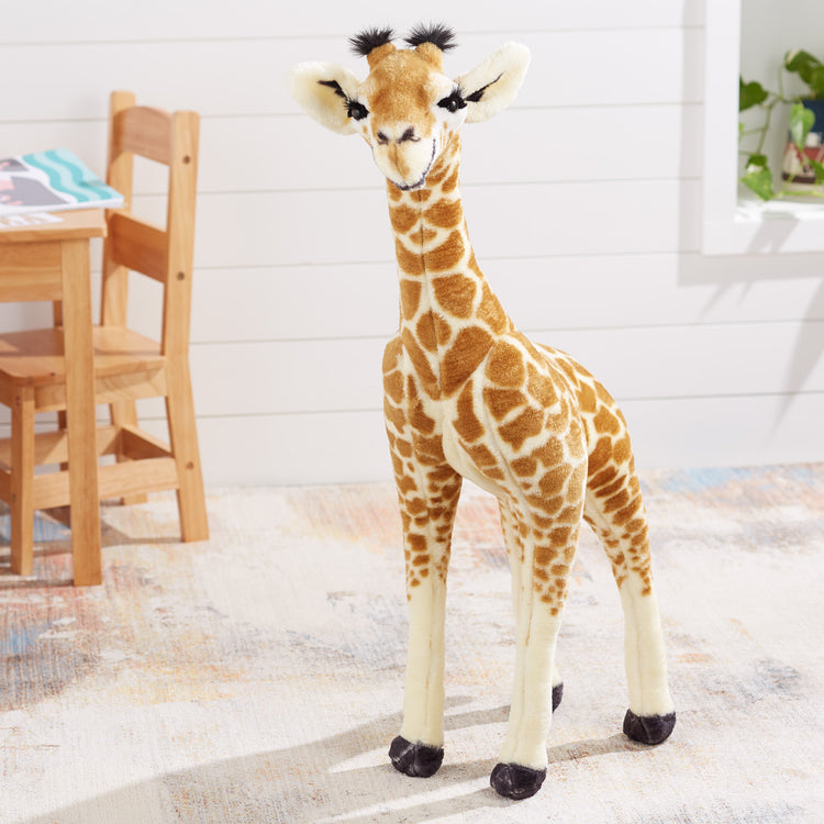 A playroom scene with The Melissa & Doug Lifelike Plush Standing Baby Giraffe Stuffed Animal – 3 Feet Tall