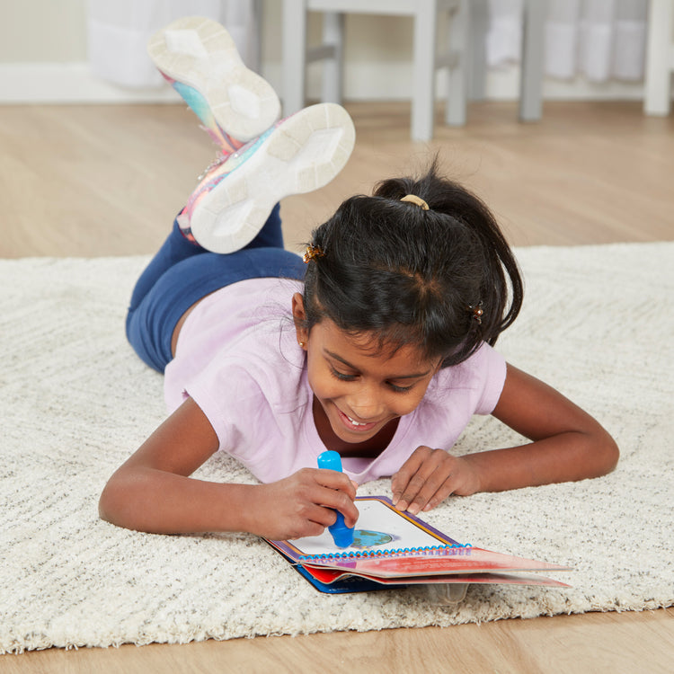 A kid playing with The Melissa & Doug On the Go Space Water Wow! Reusable Mess-Free Water-Reveal Activity Pad