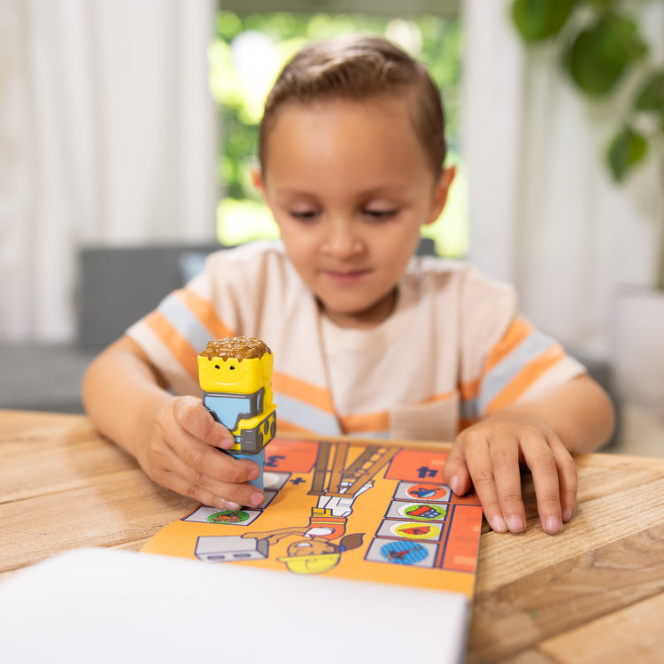 A kid playing with The Melissa & Doug Sticker WOW!™ 24-Page Activity Pad and Sticker Stamper, 300 Stickers, Arts and Crafts Fidget Toy Collectible Character – Bulldozer