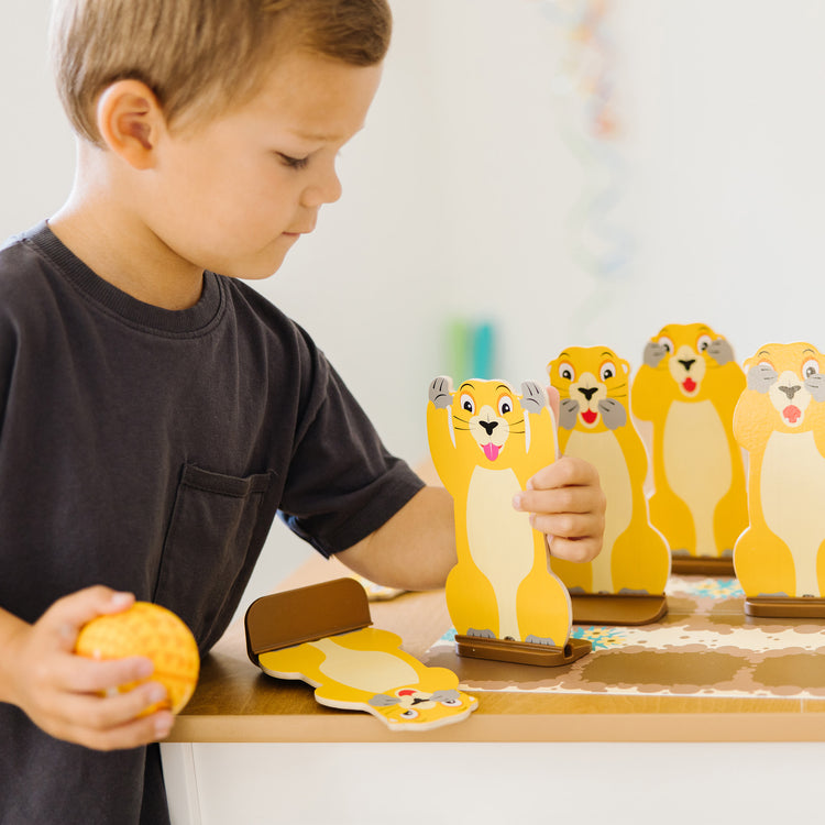 A kid playing with The Melissa & Doug Fun at the Fair! Wooden Armadillo Roll & Bowl Prairie Dog Bowling Game