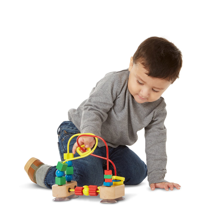 A child on white background with The Melissa & Doug First Bead Maze - Wooden Educational Toy for Floor, High Chair, or Table