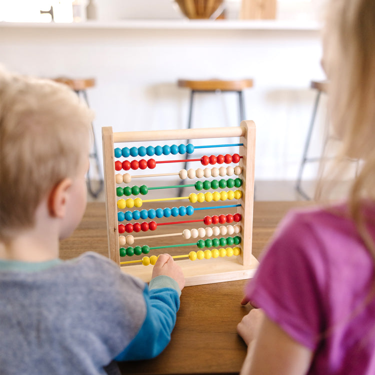 A kid playing with The Melissa & Doug Abacus - Classic Wooden Educational Counting Toy With 100 Beads