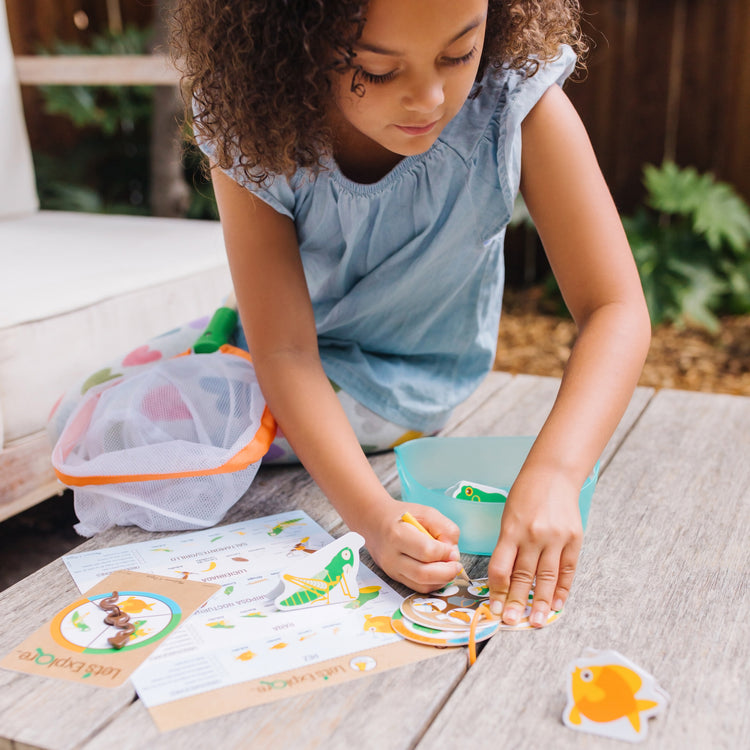 A kid playing with The Melissa & Doug Let’s Explore Critter Net Bug and Fish Catching Play Set (14 Pieces)