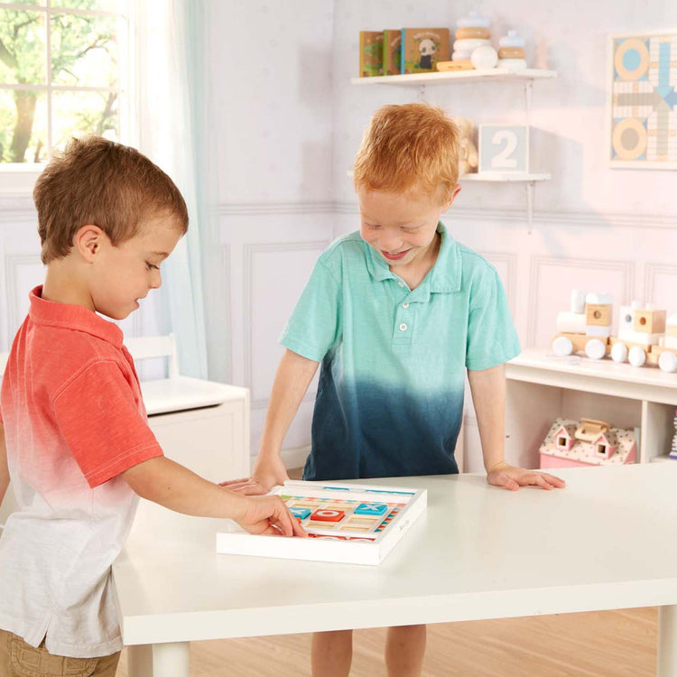 A kid playing with The Melissa & Doug Wooden Tic-Tac-Toe Board Game with 10 Self-Storing Wooden Game Pieces (12.5” W x 8.5” L x 1.25” D)