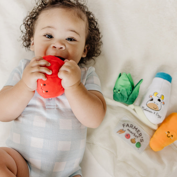 A kid playing with The Melissa & Doug Multi-Sensory Market Basket Fill & Spill Infant Toy