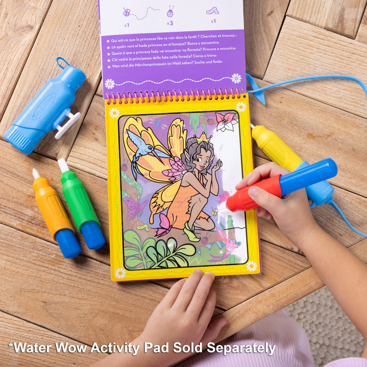 A kid playing with The Melissa & Doug Water WOW! Pen Pack - 4 Color-with-Water Pens, Sprayer, Tether Cap