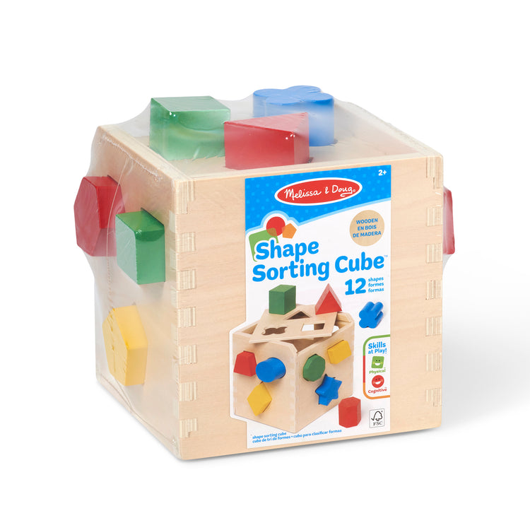 A kid playing with The Melissa & Doug Shape Sorting Cube - Classic Wooden Toy With 12 Shapes