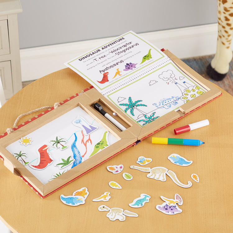 A playroom scene with The Melissa & Doug Natural Play: Play, Draw, Create Dinosaurs Drawing Activity Set & Magnet Kit - Reusable Mess-Free Travel Activity