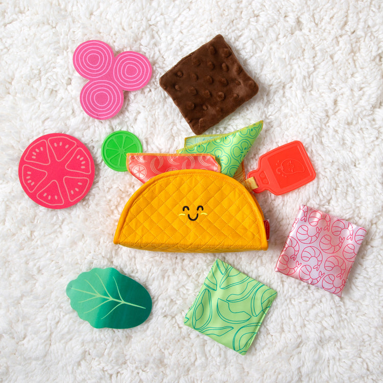 A playroom scene with The Melissa & Doug Multi-Sensory Soft Taco Fill & Spill Infant Toy