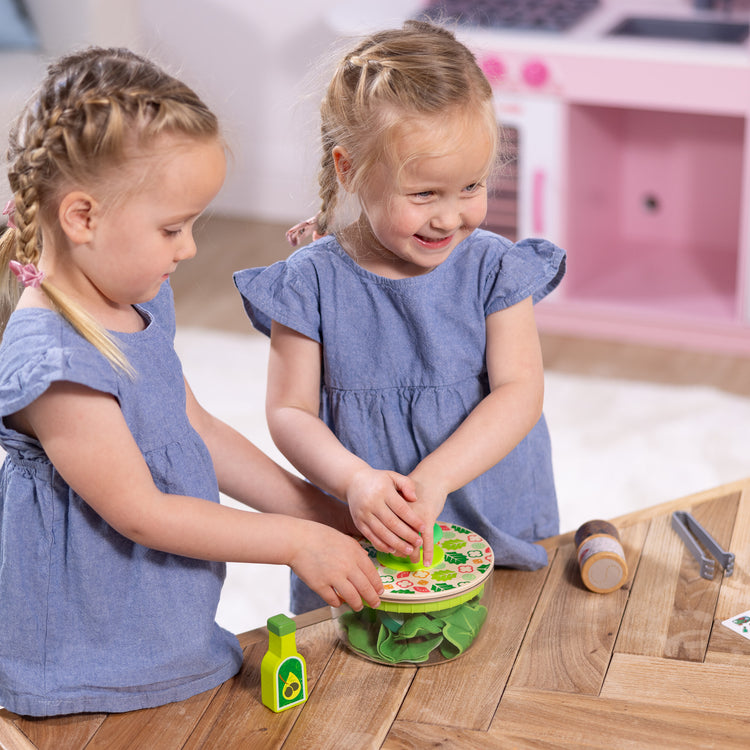 A kid playing with The Melissa & Doug Salad Spinner Play Set, Pretend Play Food for Boys and Girls Ages 3+