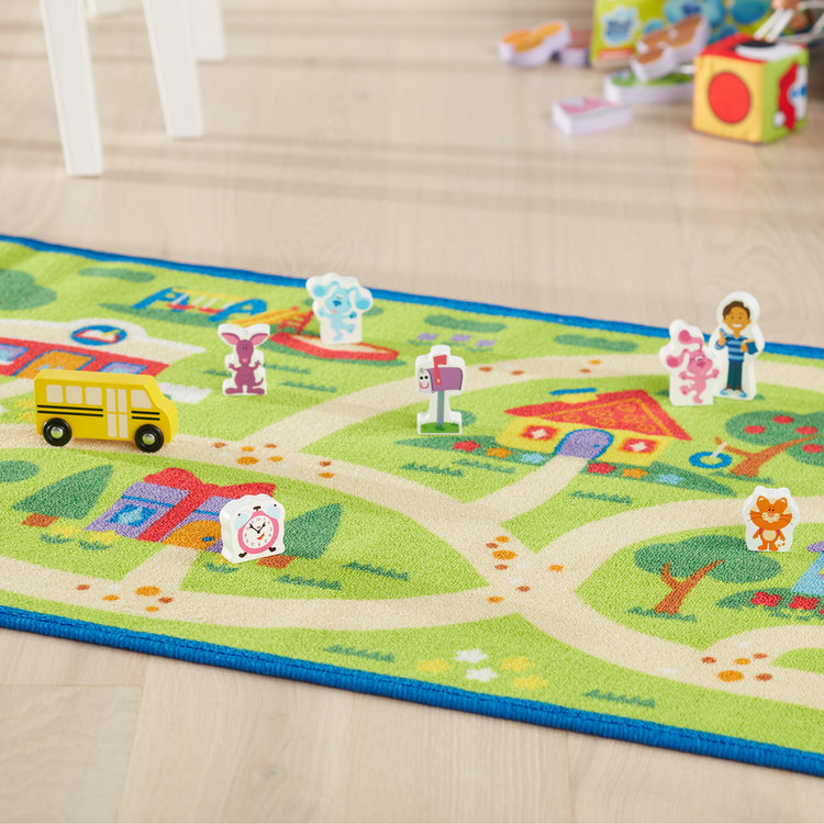 A playroom scene with The Melissa & Doug Blue's Clues & You! Blue's Neighborhood Activity Rug (44 Inches x 26 Inches Rug, 9 Wooden Play Pieces)