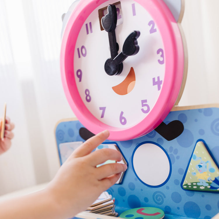 A kid playing with The Melissa & Doug Blue's Clues & You! Wooden Tickety Tock Magnetic Clock (31 Pieces)